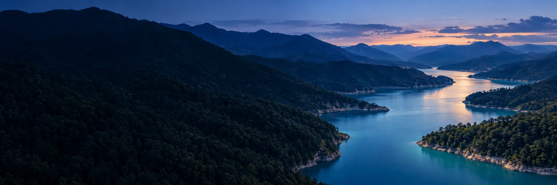 Paisaje de montañas y un lago al atardecer.