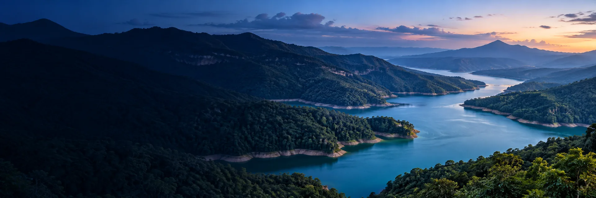 Paisaje de montañas y un lago al atardecer.